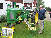 Christer Carlsson beundrar den mycket fint renoverade John Deere-traktorn.